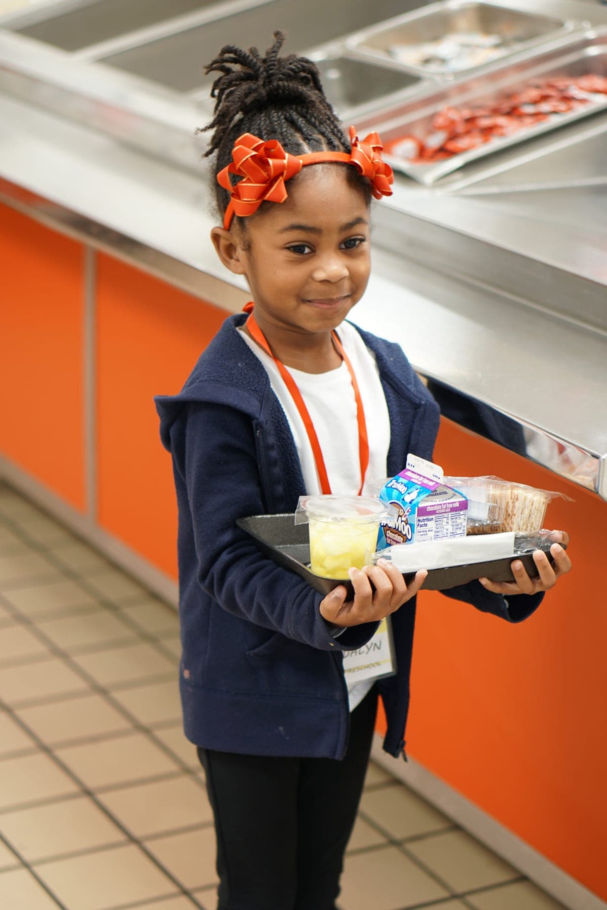 Food service staff handing packaged meals to students